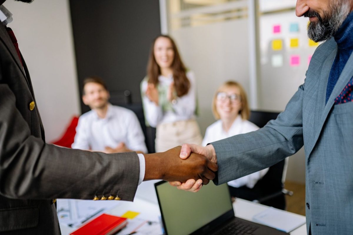 A business seller and buyer shaking hands in an office